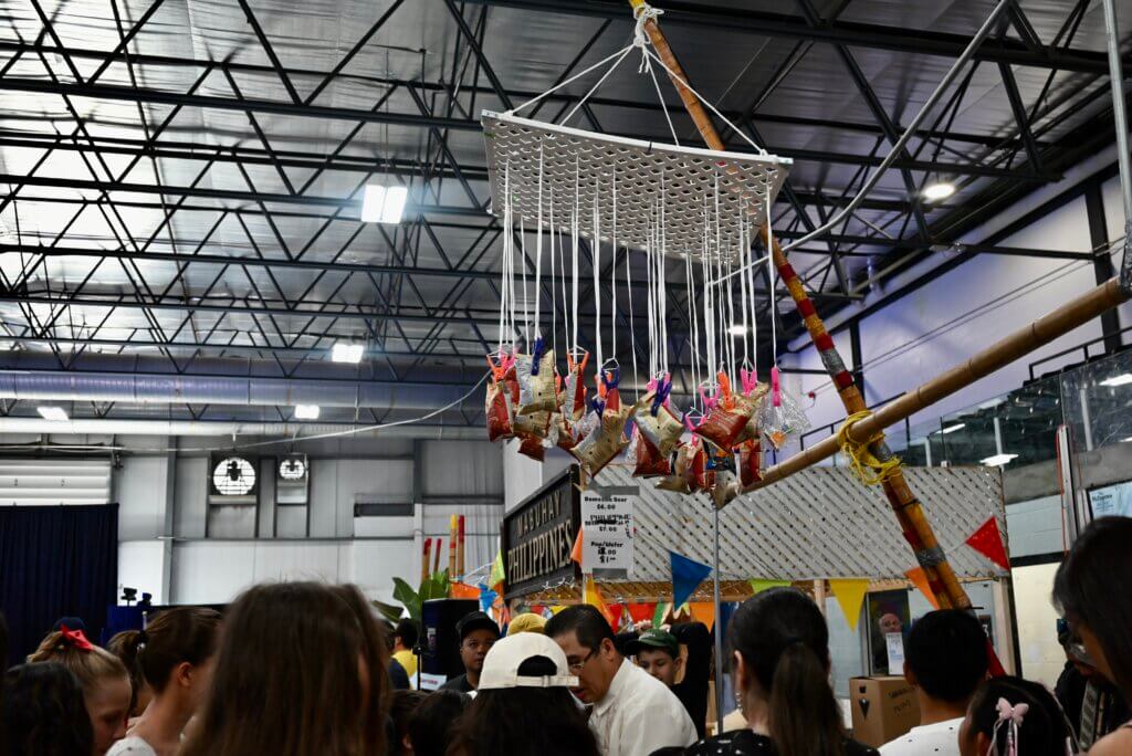 Prizes such as candy and chips are hung on strings and attached to a bamboo pole.