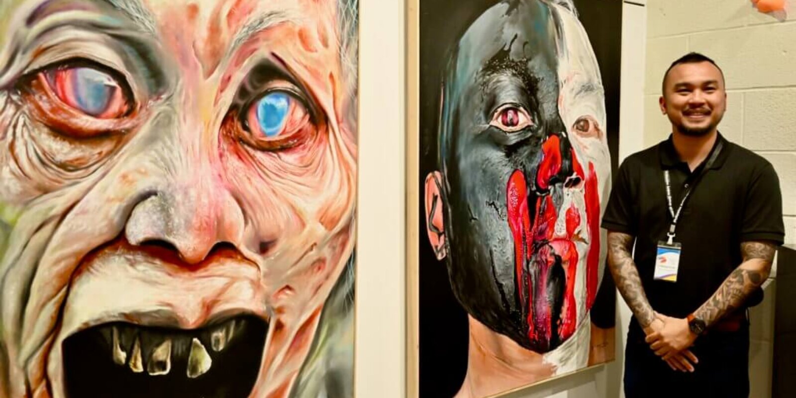 Filipino artist Peter Duarte stands beside two of his paintings.