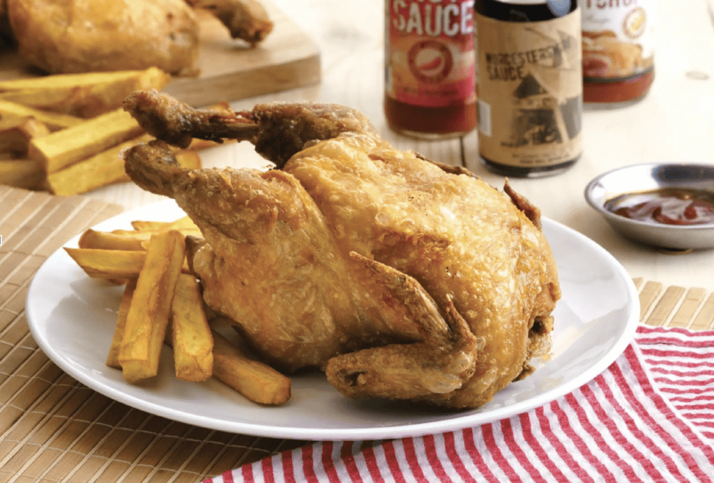 A plate on a table with fried chicken and fries on it.